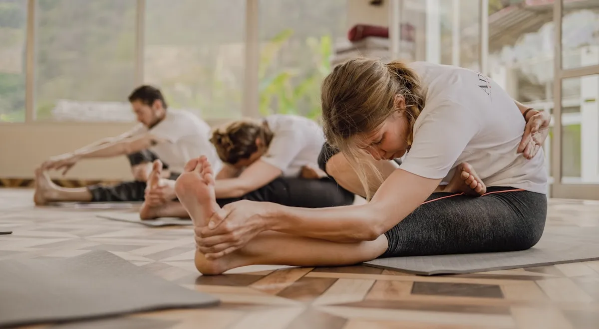 Profesora ajustando postura en formacion de yoga presencial