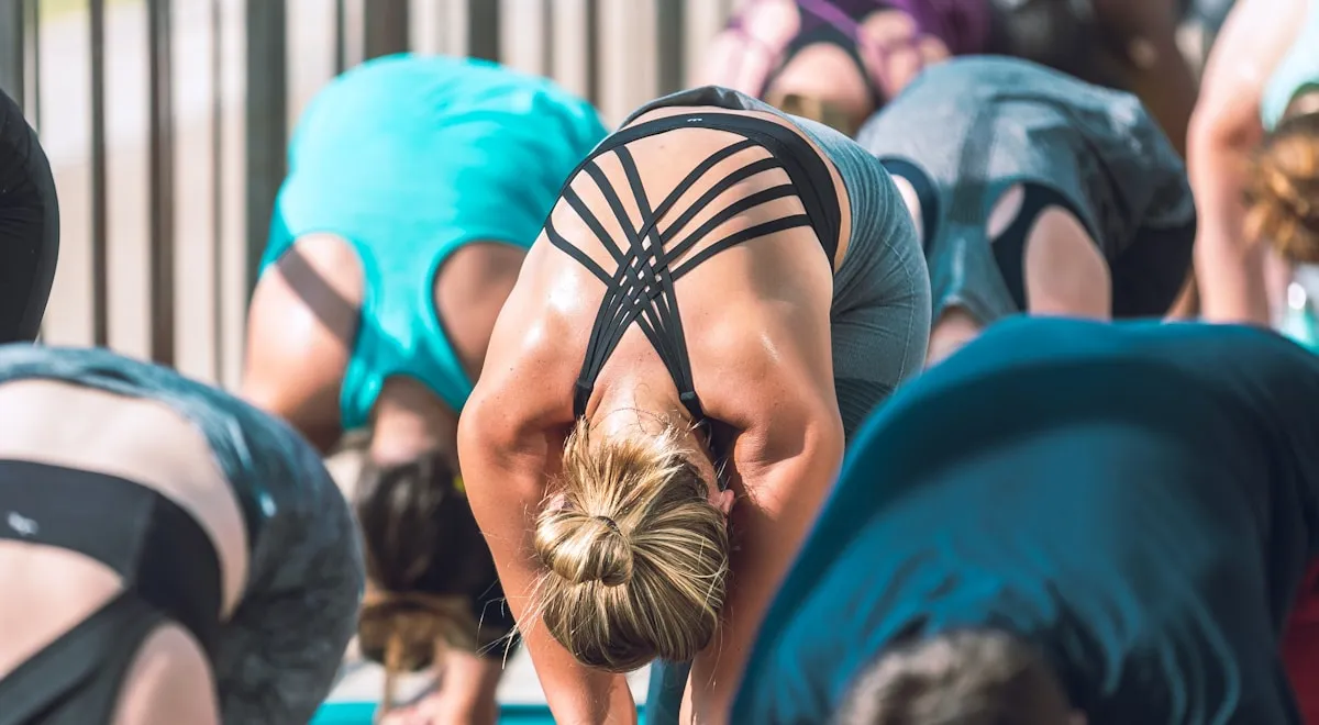 Profesora de yoga ajustando postura con criterio biomecánico