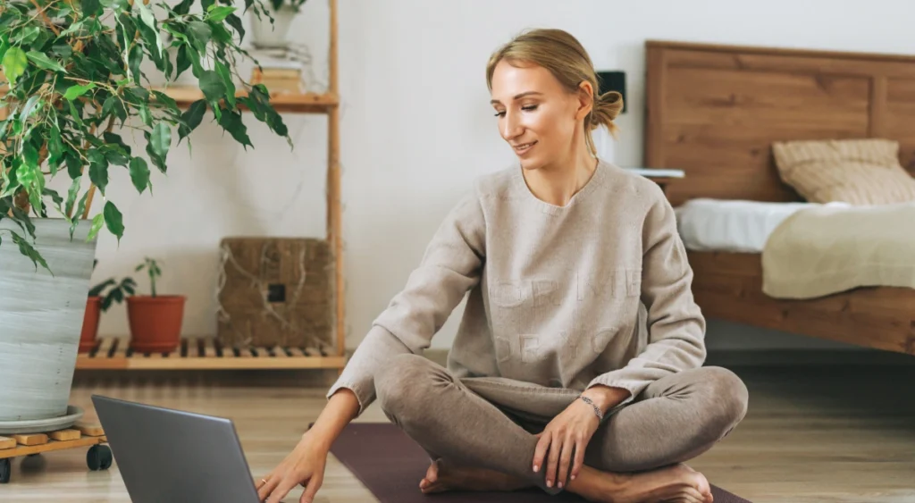 Mujer siguiendo una clase de yoga online desde casa