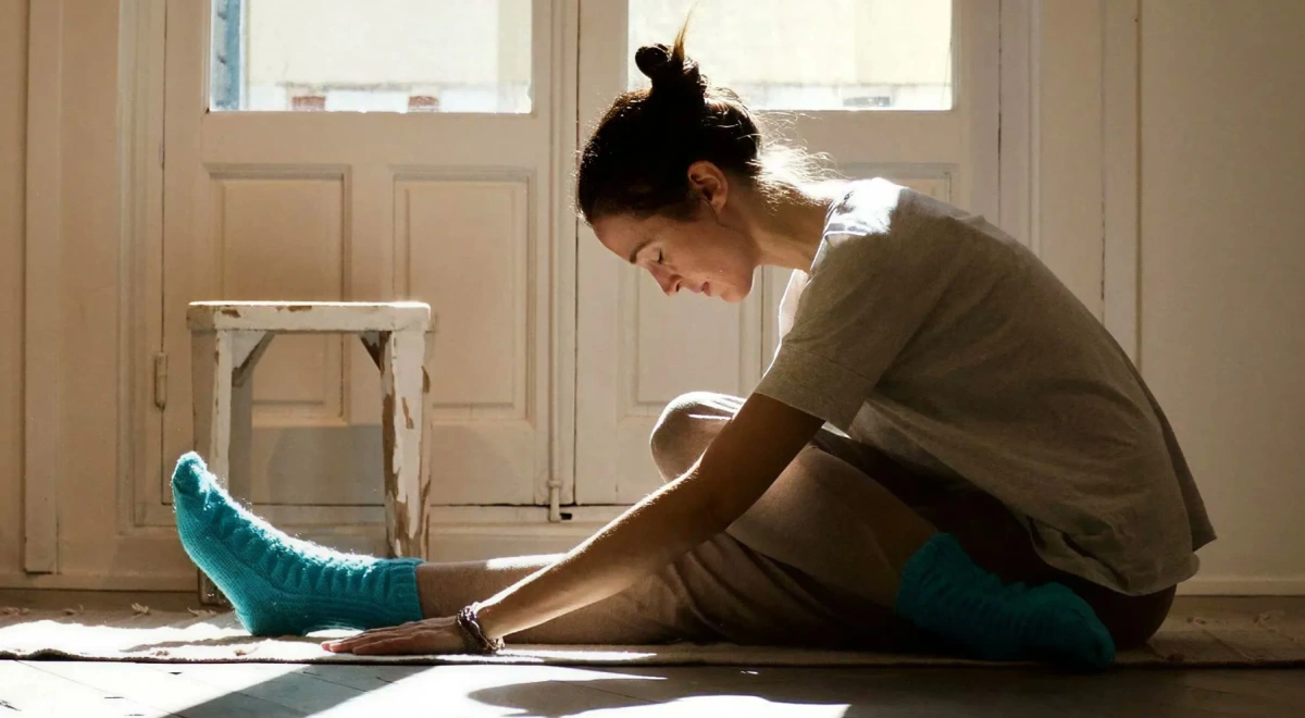 Alumna en una flexión hacia delante sentada, a su ritmo y con luz natural