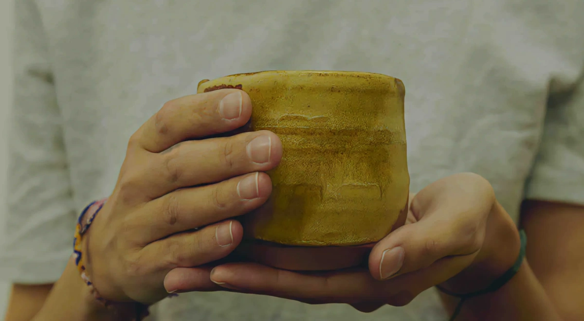 Manos que sostienen una taza de cerámica